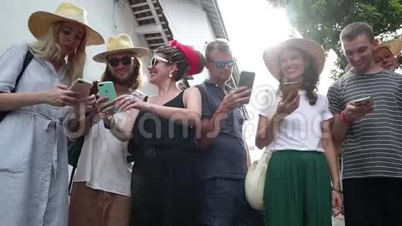 一群年轻的时髦人士正拿着智能手机站着视频的预览图