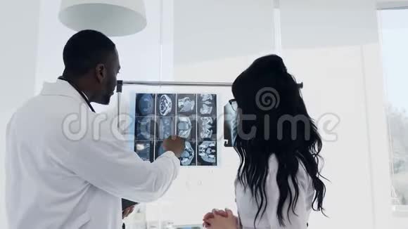 两位医生正在看x光医疗阿弗罗主任医师美国男人和高加索女人看x光视频的预览图