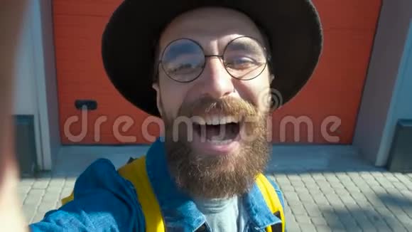 留胡子的微笑男用手机在城市街拍照片视频的预览图