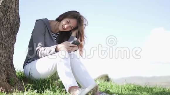一个年轻的女人玩手机视频的预览图