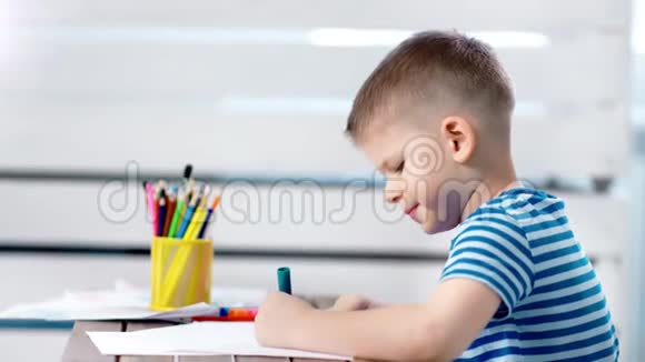 专心致志的小造物主男孩在相册里用记号笔画出美丽的彩色艺术图画视频的预览图