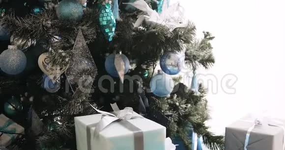 圣诞前夜一位女士在圣诞树旁放了一个礼品盒双手特写视频的预览图
