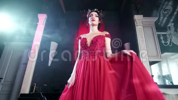 美丽优雅的女士令人惊叹的晚红连衣裙在豪华复古室内低角度跳舞视频的预览图