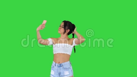 漂亮的年轻女人在绿色屏幕上自拍Chroma键视频的预览图