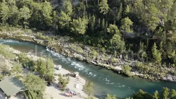 一条河流在群山中流淌在一个狭窄的深谷中陡峭的河岸和一个岩石床上堆满了岩石碎片视频的预览图