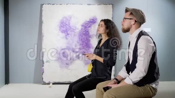 两位当代抽象艺术的年轻鉴赏家正在画廊里聊天视频的预览图