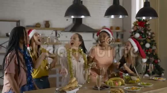 会飞的纸屑女孩们在圣诞前夜在厨房里玩得很开心朋友聚会视频的预览图