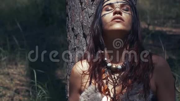 年轻的黑发亚马逊女人正在森林的树下休息视频的预览图