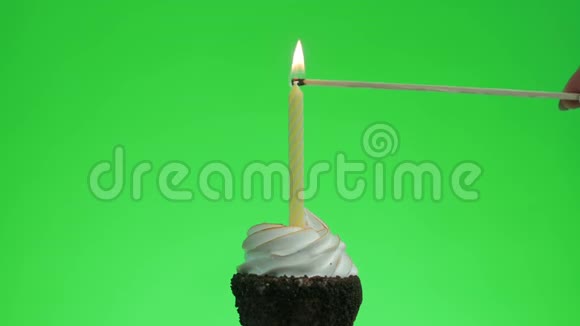 在美味的蛋糕上点燃一支黄色的蜡烛绿色的屏幕视频的预览图