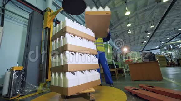 装有塑料容器的纸箱由男性装载机堆放视频的预览图