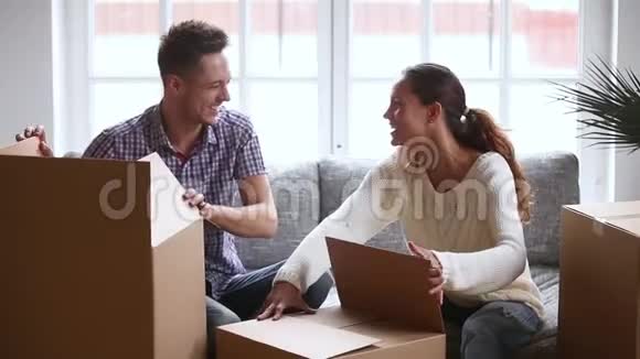 快乐的年轻夫妇笑着打开纸板箱打开纸板箱视频的预览图