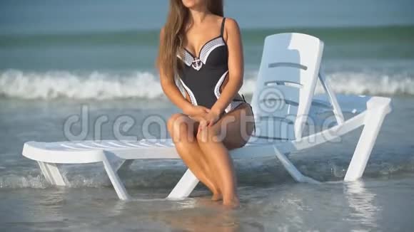 戴太阳镜的女孩坐在日光浴床上视频的预览图