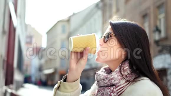 时尚的时髦微笑女人喝着咖啡纸杯欣赏欧洲建筑视频的预览图