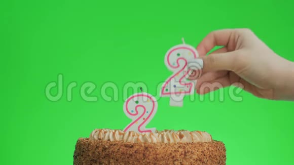 在一个美味的蛋糕上放一支二十二岁的生日蜡烛绿色的屏幕视频的预览图