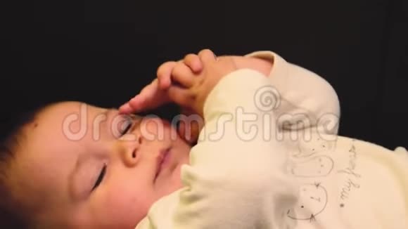 特写POV镜头可爱的困倦的六个月大的小男孩揉着眼睛试图打开侧面视频的预览图
