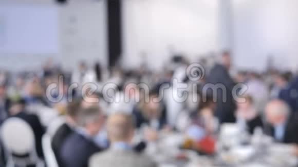 背景模糊的餐饮服务服务员在婚礼或会议上把盘子和盘子放在客人的桌子上视频的预览图