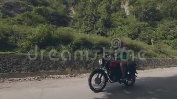 夏天骑摩托车旅行的帅哥骑摩托车骑在热带高地景观上的老人莫托视频的预览图