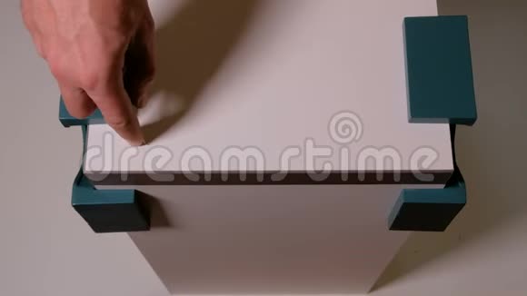 一只雄性手在白色的刨花板上用锥子刺穿一个洞家具零件使用角夹固定成直角视图视频的预览图