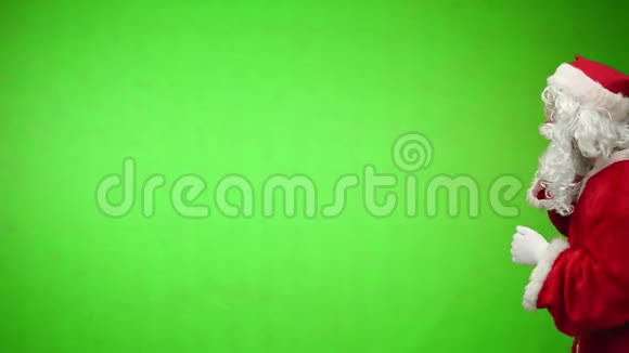 圣诞老人带着礼品袋在绿色背景下看远处Chroma键4k镜头视频的预览图