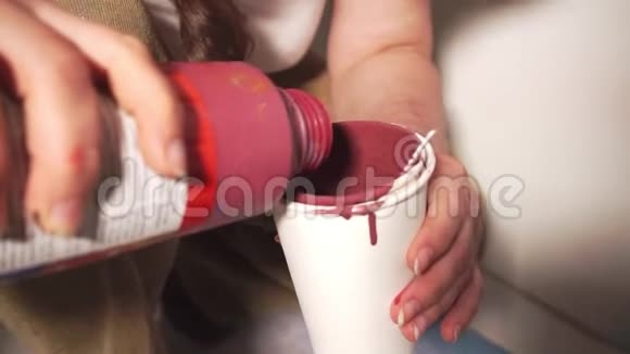 人在装饰容器上加厚红色油漆视频的预览图