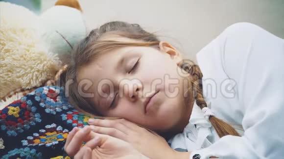 可爱迷人的孩子睡在她的白色大泰迪熊视频的预览图