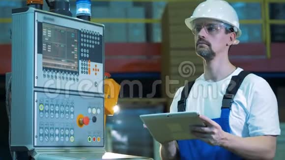 工业工程师正在监控控制台旁边操作一台笔记本电脑视频的预览图