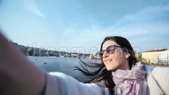 微笑优雅的女游客在河堤上自拍享受欧洲度假的POV镜头视频的预览图