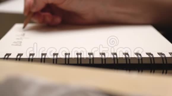 女人用铅笔在日记里做笔记快关门滑块运动视频的预览图