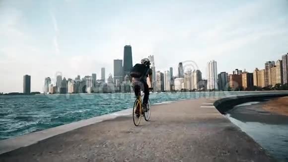 Cyclist骑在海边背景是摩天大楼视频的预览图
