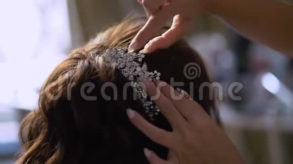 理发师给新娘头发年轻女孩的婚礼发型做发型设计师视频的预览图