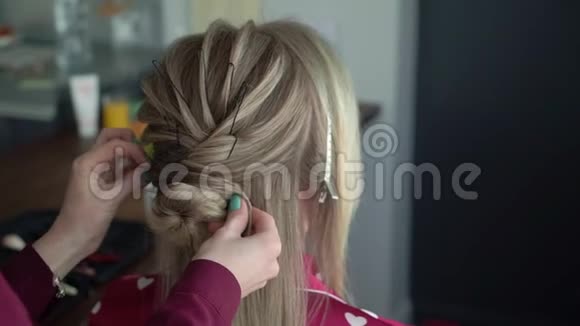 理发师给新娘头发年轻女孩的婚礼发型做发型设计师视频的预览图