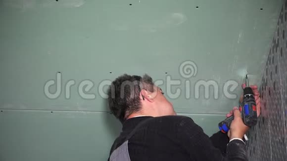 施工师傅用钻头将石膏板固定在天花板上特写视频的预览图