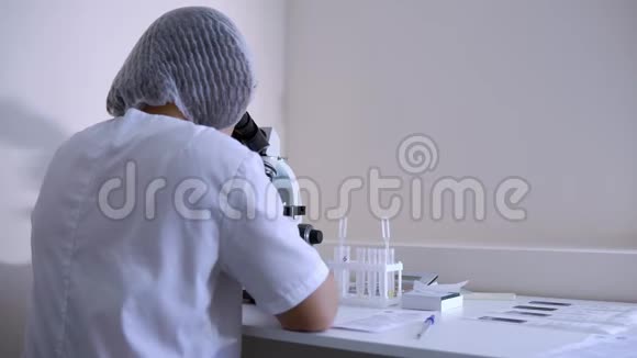 实验室助理拿着实验室显微镜坐在工作场所视频的预览图