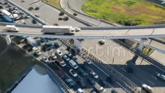 从空中观看与环形道路和城市出口交叉口的立交桥上的汽车运动视频的预览图