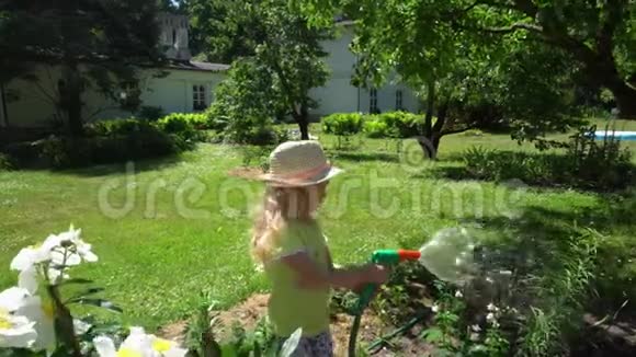 可爱的小女孩水花床与软管喷头喷雾器万向节运动视频的预览图