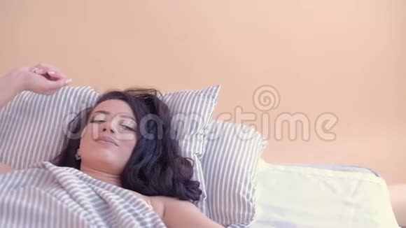 起床阳光快乐的女人醒来舒适的床回家视频的预览图