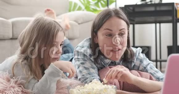 母女俩一边吃爆米花一边看电影视频的预览图