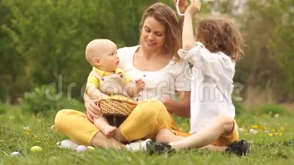 有趣的视频快乐复活节家人在公园野餐妈妈把宝宝放在复活节兔子的耳朵上视频的预览图