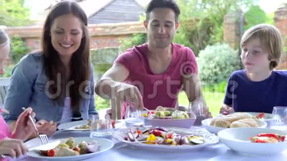 一家人围坐在户外餐桌边吃饭视频的预览图