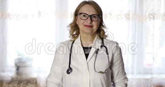 戴着听诊器戴眼镜的老女医生的肖像视频的预览图