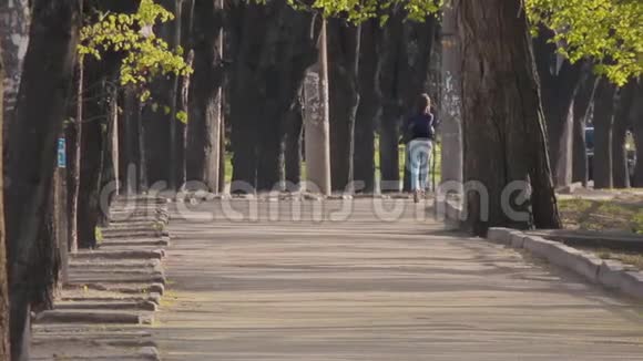 穿着牛仔裤和衬衫的年轻女孩沿着马路跑视频的预览图