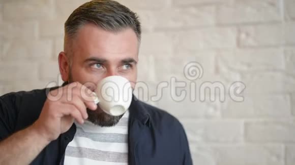 英俊的大胡子男人在咖啡厅放松喝咖啡或茶好心情视频的预览图