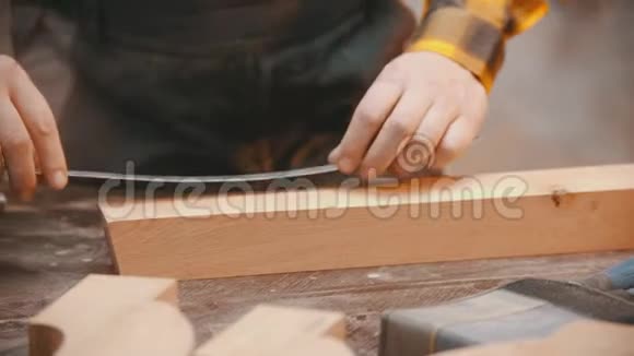 室内木工一名木工用铅笔和尺子在木制细节上做记号视频的预览图