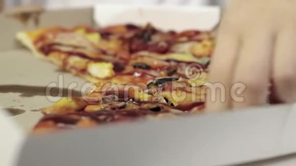 女孩手上的特写拿着一块多汁油腻的披萨放进嘴里不健康的食物概念视频的预览图