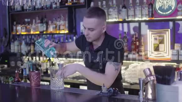 酒吧里的专业酒保在杯子里放长勺子冰块派对时间视频的预览图