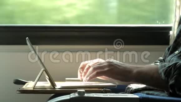 男人在火车上用手在笔记本电脑上打字视频的预览图