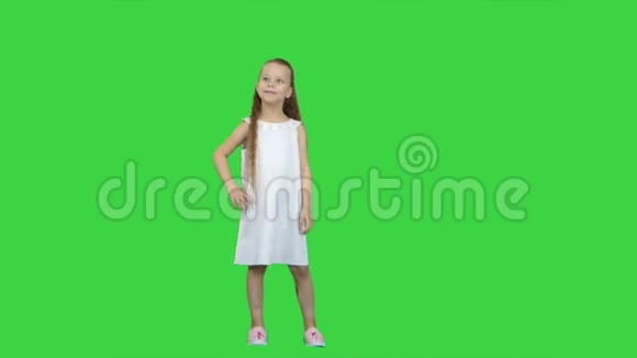 可爱的小女孩在镜头前微笑在绿色屏幕上摆姿势Chroma键视频的预览图