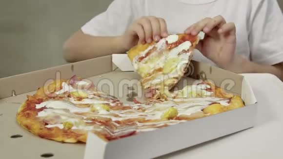 小手拿着一块多汁油腻的披萨把它送到嘴里穿着白色t恤的有趣女孩视频的预览图