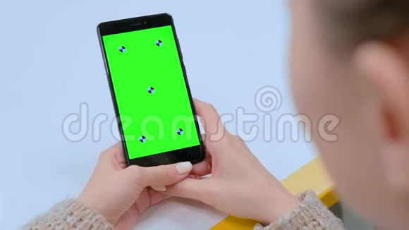 女人触摸黑色智能手机空白绿色屏幕刷卡手势视频的预览图