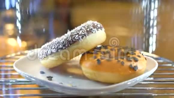 让人兴奋的甜甜圈在咖啡店的橱窗里旋转视频的预览图